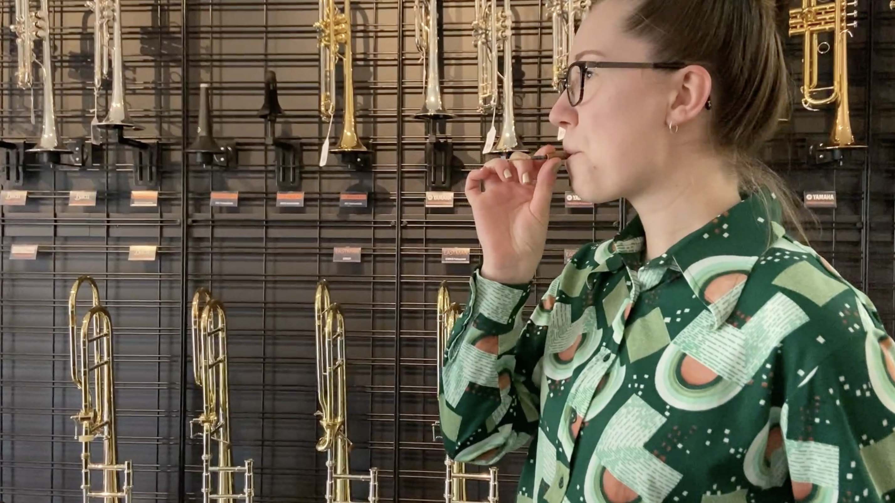 Person blowing through oboe reed.